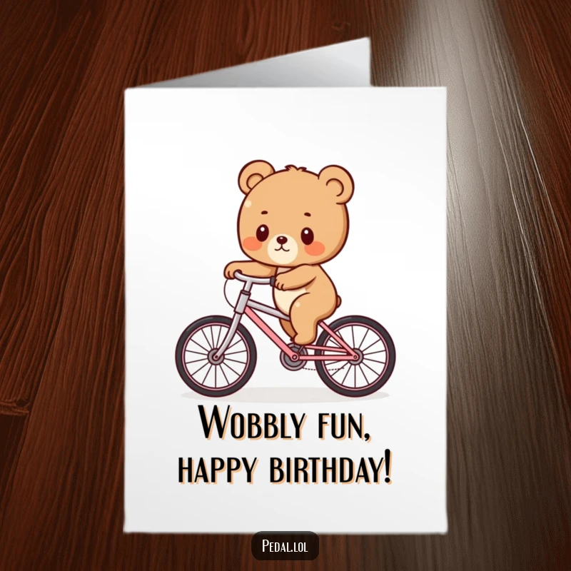 Funny free printable birthday card showing a cute bear cub struggling hilariously to balance on a wobbly bicycle.